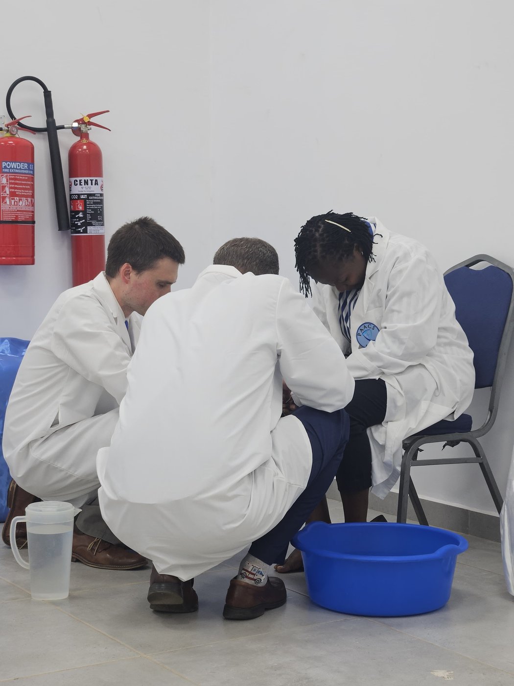 Senior surgeons wash the feet of new PAACS residents at their induction